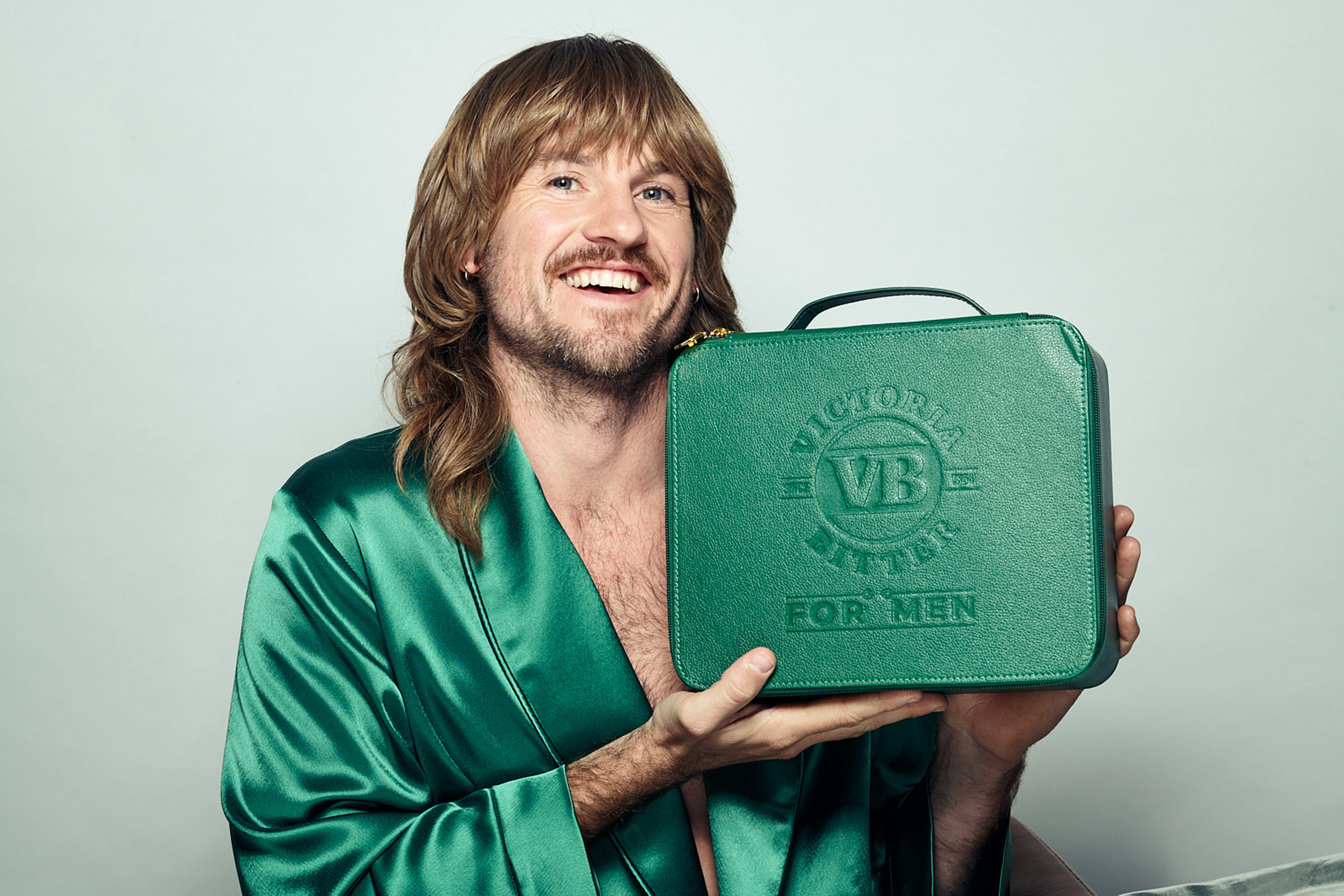 A man holding up a mens grooming range in his hand